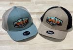 Picture of two hats, one is blue with brown mesh and one is brown with black mesh.